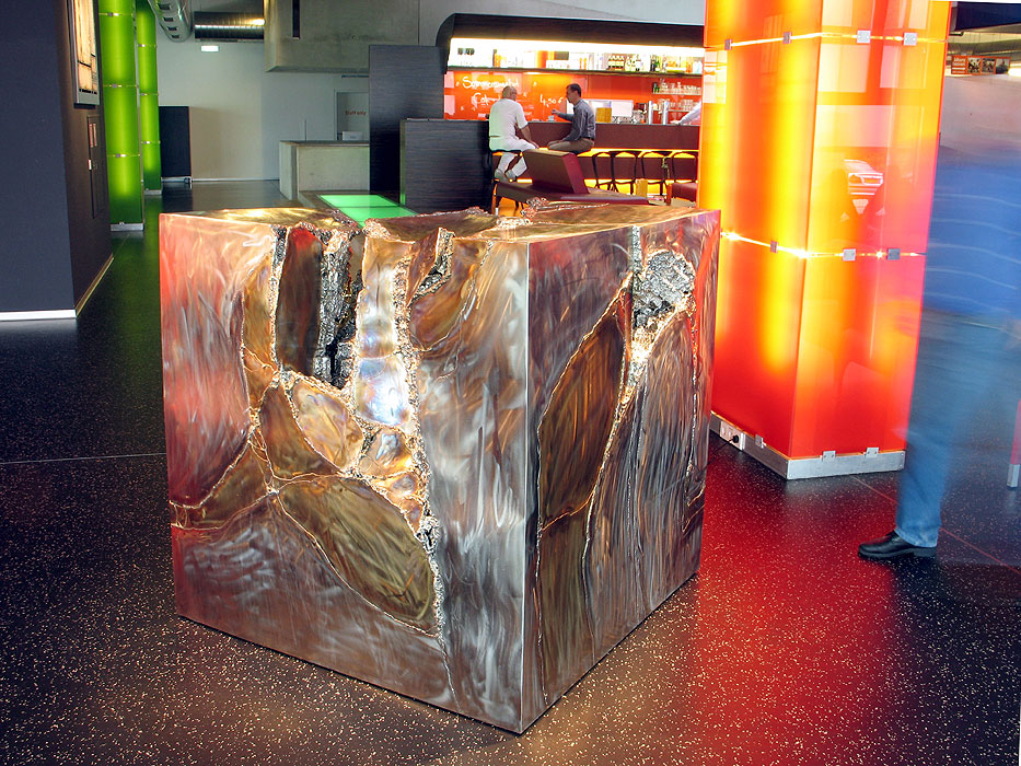 This fountain sculpture looks like a melted steel cube